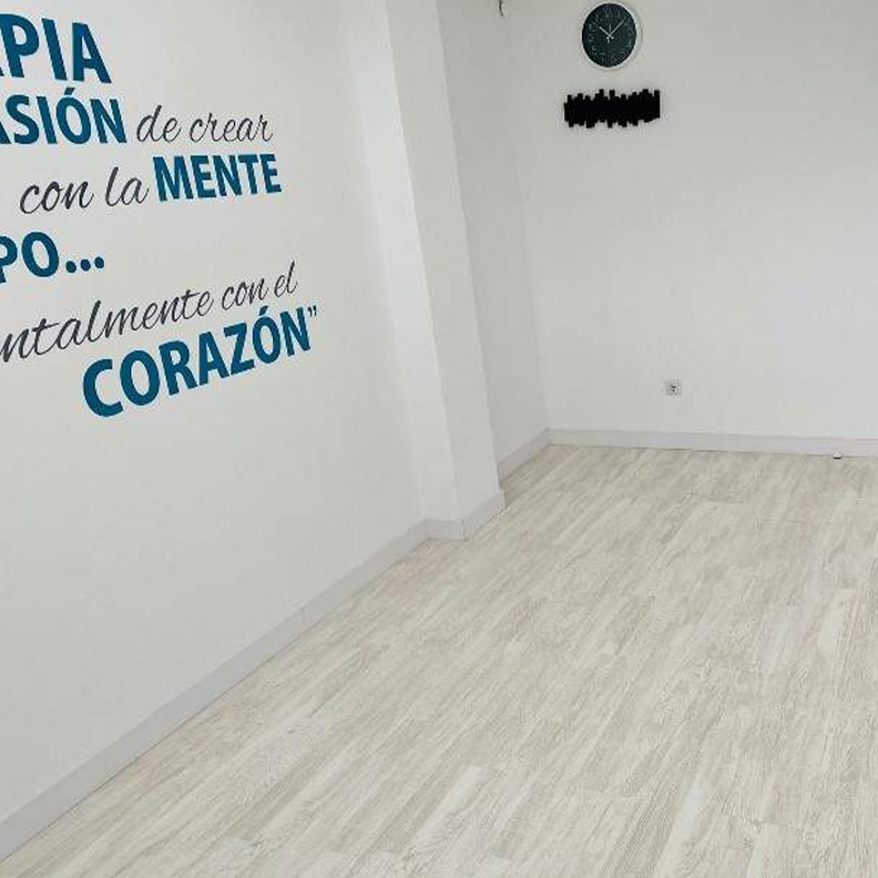 Sala para fisioterapia vacía con reloj en la pared de clínica Jessica Menchero